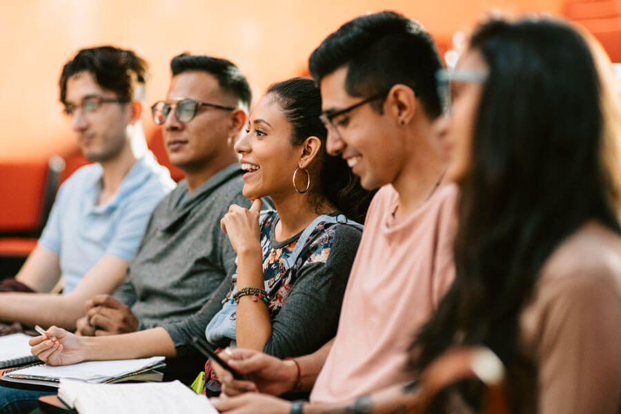 hispanic students taking notes at lecture